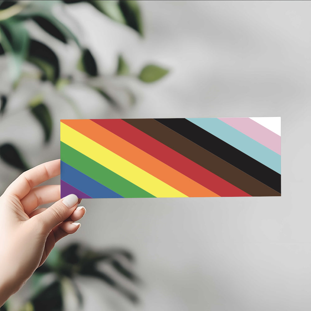 Hand holding rainbow bumper sticker with 11 stripes