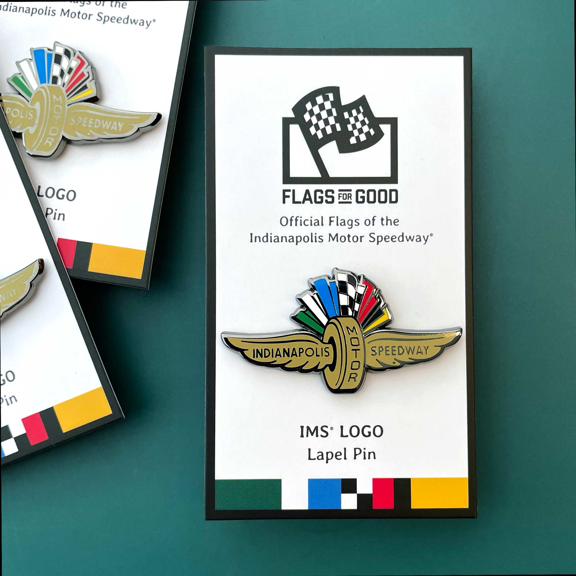 Indianapolis Motor Speedway wing and wheel logo-shaped pin on a white card with "Flags for Good" printed on top of product card