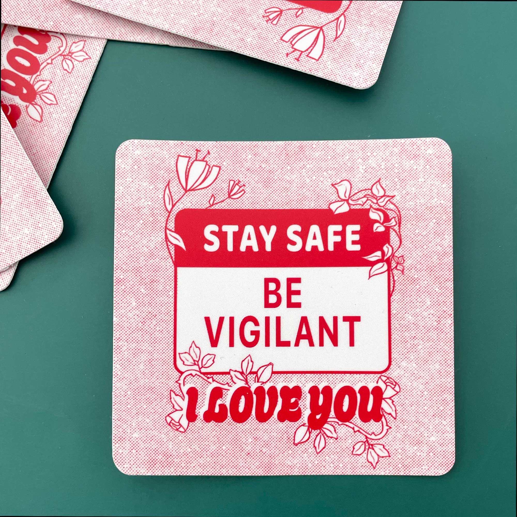 large red and white square sticker with 'Stay Safe, Be Vigilant, I Love You' text on a green background