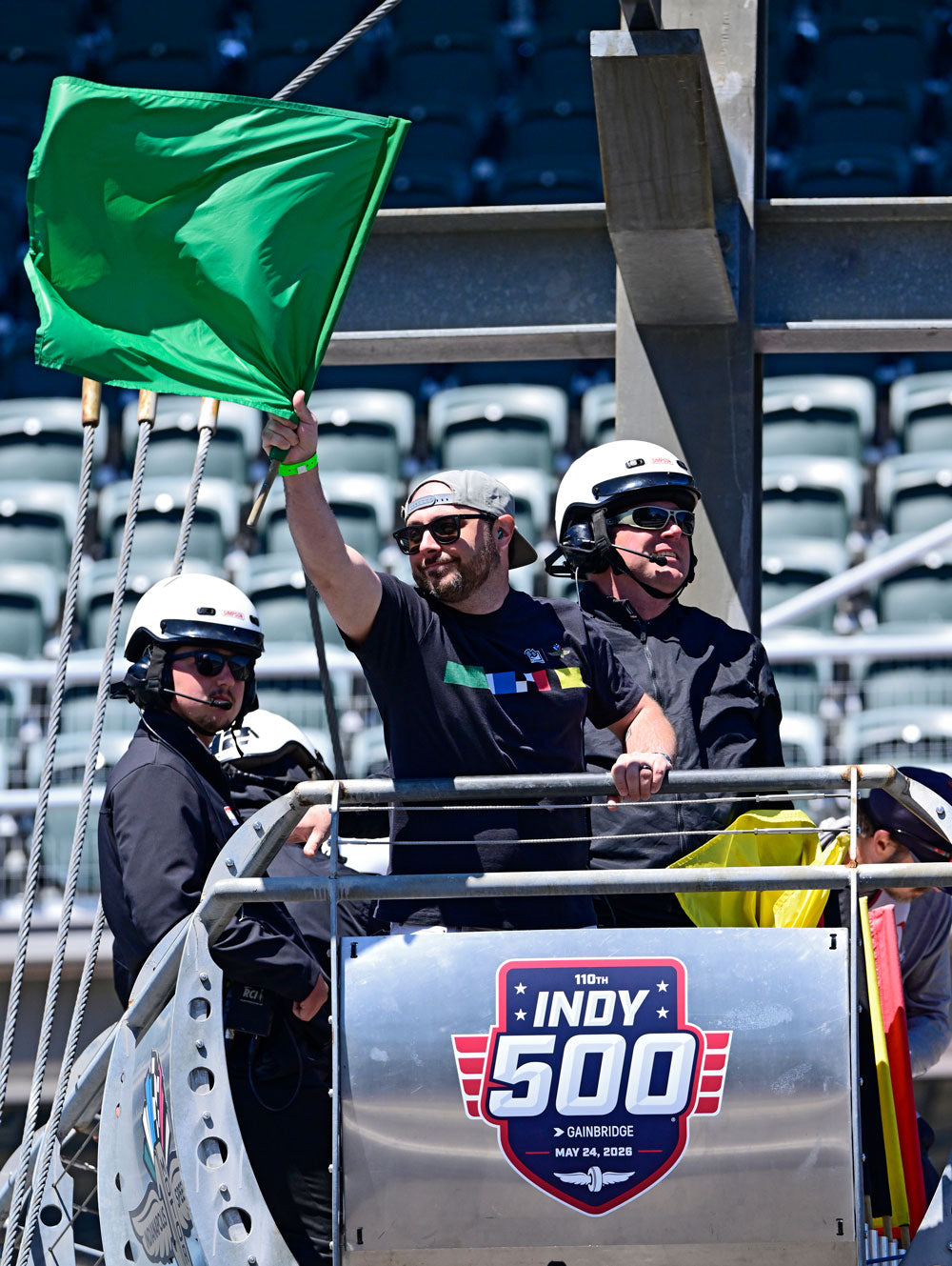 Flags for Good CEO Michael Green waving a green flag at an Indianapolis 500 practice 